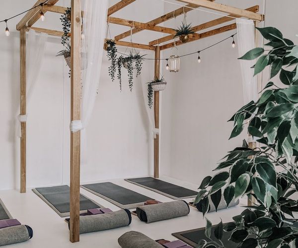 Interior of a calm and minimalist yoga studio with soft lighting.